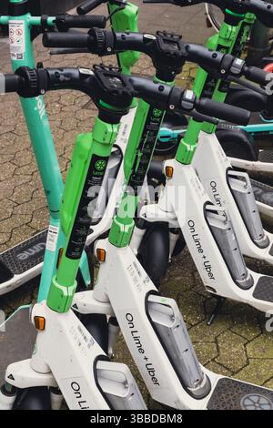 Gruppe von E-Scootern, die auf einer gemeinsamen Station geparkt sind Stockfoto