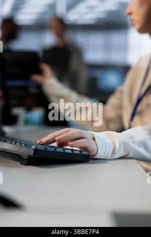 Techniker im Serverraum, der über die Tastatur schreibt und Energieverwaltungslösungen implementiert, um den Energieverbrauch zu senken. Nahaufnahme eines IT-Spezialisten, der neue Technologien und Systeme in Rechenzentren integriert Stockfoto