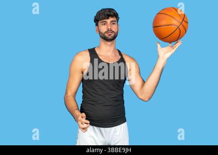 Junger Mann, der geschickt einen Basketball auf seinem Finger dreht Stockfoto