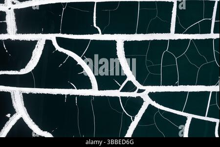 Hintergrund in Form von weißen breiten Rissen auf schwarzem Hintergrund. Stockfoto