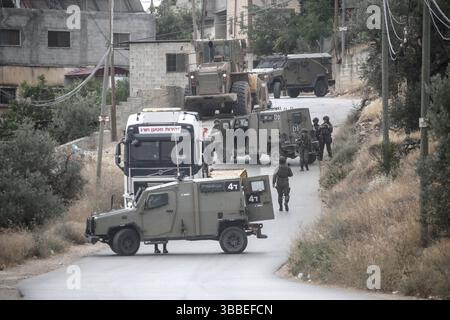 Nablus, Palästina. Mai 2025. Israelische Truppen sperren das Gebiet ab und umgeben ein Haus während der Militäroperation. Die israelische Armee umzingelte ein Gebäude während einer Militäroperation, bei der fünf Palästinenser getötet wurden, die sich darin verbarrikadiert hatten. In der Stadt Tammun, nördlich des Jordantals im Westjordanland, brach ein Feuerwechsel zwischen Palästinensern und der israelischen Armee aus. Quelle: SOPA Images Limited/Alamy Live News Stockfoto