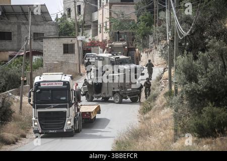 Nablus, Palästina. Mai 2025. Israelische Truppen sperren das Gebiet ab und umgeben ein Haus während der Militäroperation. Die israelische Armee umzingelte ein Gebäude während einer Militäroperation, bei der fünf Palästinenser getötet wurden, die sich darin verbarrikadiert hatten. In der Stadt Tammun, nördlich des Jordantals im Westjordanland, brach ein Feuerwechsel zwischen Palästinensern und der israelischen Armee aus. Quelle: SOPA Images Limited/Alamy Live News Stockfoto