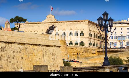 VALLETTA, MALTA - 12. NOVEMBER 2018 - Außenansicht der Auberge de Castille auf dem Castille-Platz, bei dem Leute vorbeigehen Stockfoto
