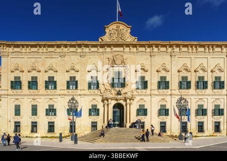 VALLETTA, MALTA - 12. NOVEMBER 2018 - Außenansicht der Auberge de Castille auf dem Castille-Platz, bei dem Leute vorbeigehen Stockfoto