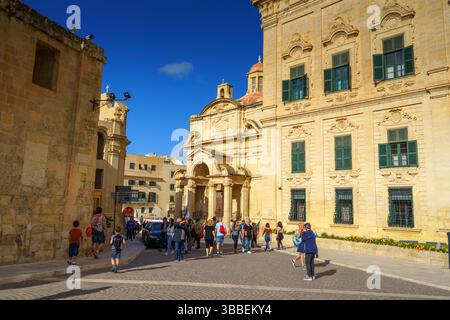 VALLETTA, MALTA - 12. NOVEMBER 2018 - Außenansicht der Auberge de Castille auf dem Castille-Platz, bei dem Leute vorbeigehen Stockfoto