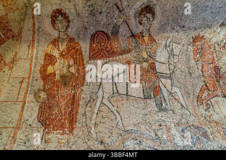Ein Fresko des Heiligen Onesimus und des Heiligen Georg zu Pferd bedeckt eine Mauer in der Schlangenkirche in Goreme mit byzantinischen religiösen Details. Stockfoto