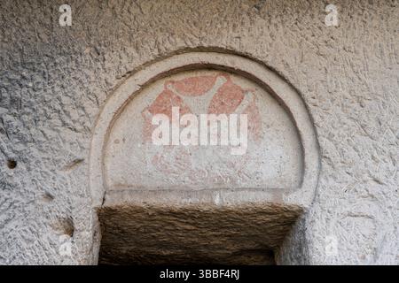 Ein einfacher Steinbogen ist in die Wand der Dunklen Kirche in Goreme gemeißelt, der minimalistischen byzantinischen Architektur widerspiegelt. Stockfoto