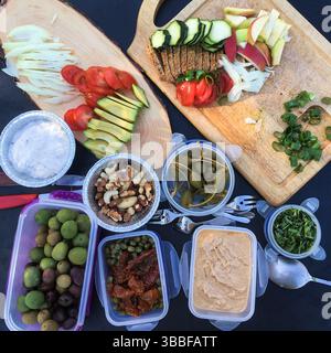 Gesunde variable Fingerfood, alles natürlich. Picknick in der Natur, Oliven, Äpfel, Avocados, Tomaten, Nüsse, Quellen, Artischocken. Einfach, keine Fertiggerichte. Stockfoto
