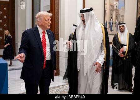 Präsident Donald Trump geht mit Amir von Katar Scheich Tamin bin Hamad Al Thani im Lusail Palace vor einem offiziellen Staatsessen am Mittwoch, den 14. Mai 2025, in Doha. Katar. (Offizielles Foto des Weißen Hauses von Daniel Torok) Stockfoto