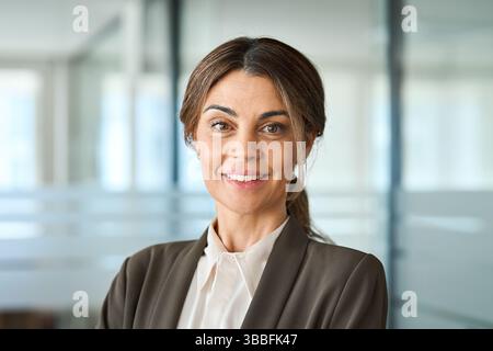 Selbstbewusste, glückliche, reife Geschäftsfrau, die im Büro steht, Kopffoto-Porträt. Stockfoto