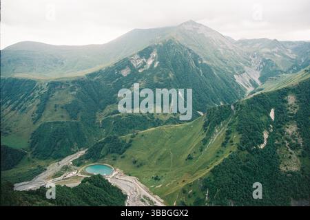 Rund um den blauen Bergsee und die grünen Berggipfel in Georgia. Körniger Film im Stil alter Fotos Stockfoto