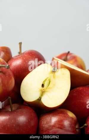 Gruppe frischer roter ganzer Äpfel und Apfelhälften Nahaufnahme. Stockfoto