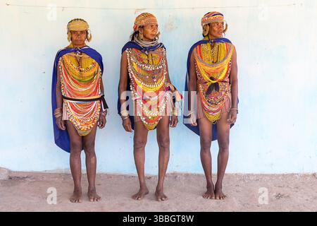 Frauen aus dem Stamm Bonda in farbenfroher traditioneller Kleidung und wunderschönen Halsketten posieren für ein Foto in einem kleinen Dorf im ländlichen Orissa, Indien Stockfoto