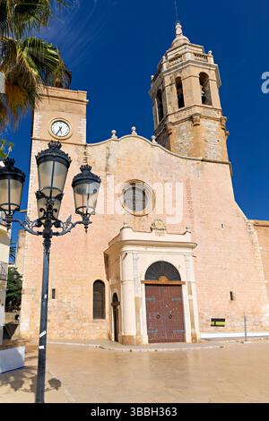 Sitges Spanien Kirche mit Blick auf das Mittelmeer mit Menschen, die entlang der Promenade spazieren gehen Stockfoto