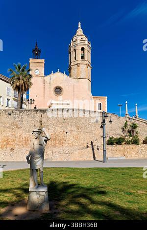 Sitges Spanien Kirche mit Blick auf das Mittelmeer mit Menschen, die entlang der Promenade spazieren gehen Stockfoto