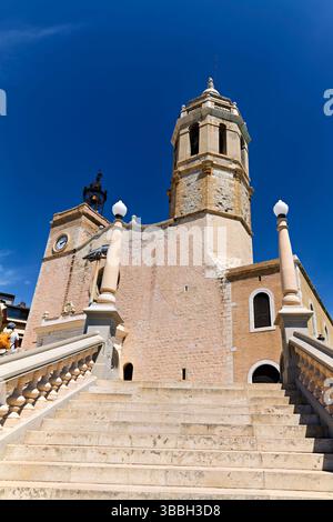 Sitges Spanien Kirche mit Blick auf das Mittelmeer mit Menschen, die entlang der Promenade spazieren gehen Stockfoto
