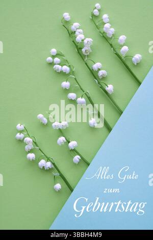 Die Blumen der Tallilie sind diagonal auf einem grün-blauen Hintergrund angeordnet, mit dem deutschen Text „alles Gute zum Geburtstag“, was „alles Gute zum Geburtstag“ bedeutet Stockfoto