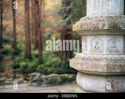 Verwitterte Steinpagode mit buddhistischem Relief im Herbstwald am Hupao Tiger Spring, Hangzhou Stockfoto
