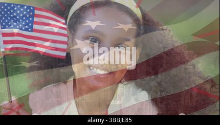 Bild einer us-Flagge über glücklichem afroamerikanischen Mädchen, das vor der Kamera lächelt Stockfoto
