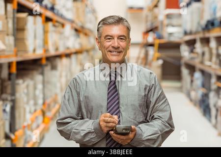 Scannen eines leitenden Mitarbeiters, der die Lagerbestände im Lagerhaus inspiziert, mit Barcode-Handleser und -Boxen Stockfoto