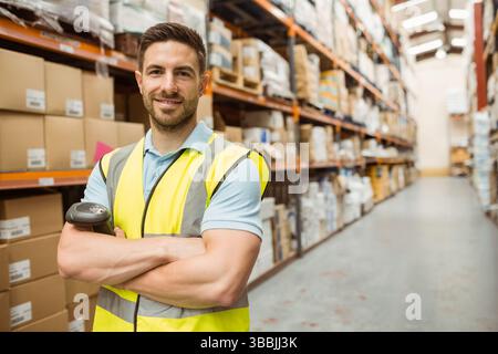 Männlicher Lagerarbeiter, der Barcodes im Lagergang scannt, mit Scanner und Boxen, Kopierraum Stockfoto