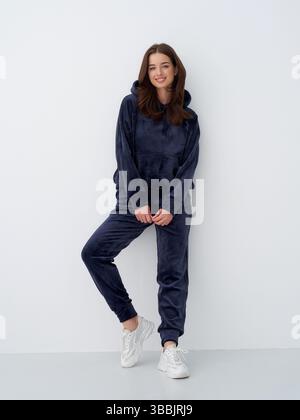 Lässiges Ambiente im Innenbereich mit einer Frau in einem marineblauen Loungewear-Outfit Stockfoto