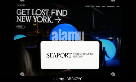 Stuttgart, Deutschland - 01-07-2024: Person mit Mobiltelefon mit Logo des US-amerikanischen Unternehmens Seaport Entertainment Group Inc. Auf dem Bildschirm Stockfoto