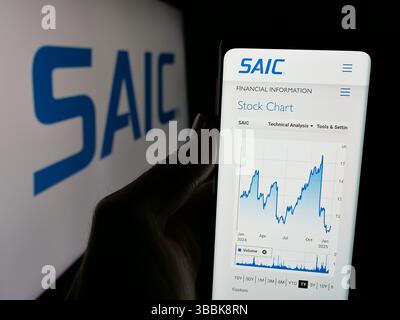 Stuttgart, Deutschland - 01-07-2024: Person, die ein Mobiltelefon hält, mit Webseite der Science Applications International Corporation (SAIC) auf dem Bildschirm mit Logo. Stockfoto