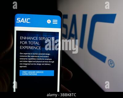 Stuttgart, Deutschland - 01-07-2024: Person, die ein Mobiltelefon hält, mit Webseite der Science Applications International Corporation (SAIC) auf dem Bildschirm mit Logo. Stockfoto
