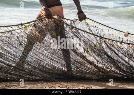 Der halbe Körper eines nicht identifizierten Fischers, der ein Fischernetz zieht. Fisch und Meeresfrüchte, Hobby. Brasilien Stockfoto