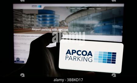 Stuttgart, Deutschland - 15.01.2025: Person, die ein Mobiltelefon mit dem Logo der deutschen Firma APCOA Parking Holdings GmbH auf dem Bildschirm hält Stockfoto