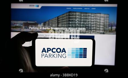 Stuttgart, Deutschland - 15.01.2025: Person, die ein Mobiltelefon mit dem Logo der deutschen Firma APCOA Parking Holdings GmbH auf dem Bildschirm hält Stockfoto