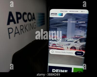 Stuttgart, Deutschland - 15.01.2025: Person, die ein Smartphone hält, mit der Webseite der deutschen Firma APCOA Parking Holdings GmbH vor dem Logo auf dem Bildschirm. Stockfoto