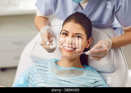 Schöne Frau lächelt, während sie beim Zahnarzt sitzt, Nahaufnahme Stockfoto