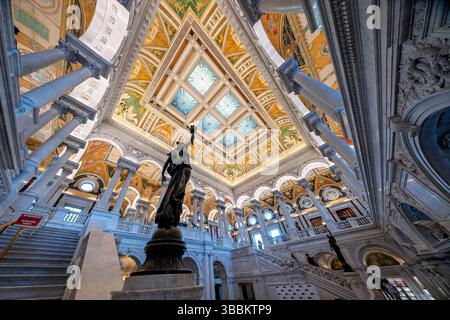 WASHINGTON DC – die große Halle des Thomas Jefferson Building an der Library of Congress verfügt über eine monumentale Marmortreppe, die von weiblichen Bronzestuppen mit hochgezogenen Armen flankiert wird, die brennerähnliche Elektroliere halten. Diese allegorischen Statuen, die in den 1890er Jahren vom Bildhauer Philip Martiny geschaffen wurden, dienen sowohl als dekorative Elemente als auch als funktionale Leuchten im kunstvollen Beaux-Arts-Innenraum. Die 1897 fertiggestellte große Halle zeigt kunstvolle Marmorsäulen, vergoldete Ornamente, Mosaikböden und eine Kassettendecke mit verkupferten Oberlichtern, die beispielhaft für die amerikanische Renaissance ist Stockfoto