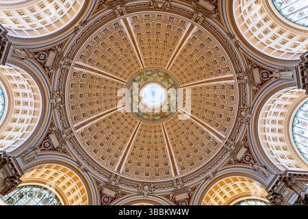 WASHINGTON DC – die reich verzierte Kuppeldecke des Hauptlesungssaals im Thomas Jefferson Building der Library of Congress steht für den Höhepunkt des amerikanischen Beaux-Arts-Designs. Die 1897 fertiggestellte 160 Meter hohe Kuppel zeigt Edwin Howland Blashfields zentrales Gemälde „menschliches Verständnis“, umgeben von zwölf Figuren, die Länder und Epochen repräsentieren, die zum menschlichen Wissen beigetragen haben. Die Decke enthält kunstvoll vergoldete Formteile, farbenfrohe allegorische Gemälde im Kragen der Kuppel und Personifizierungen von Literatur, Wissenschaft und Kunst. Dieses Meisterwerk von Amer Stockfoto