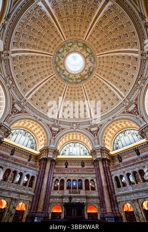 WASHINGTON DC – die reich verzierte Kuppeldecke des Hauptlesungssaals im Thomas Jefferson Building der Library of Congress steht für den Höhepunkt des amerikanischen Beaux-Arts-Designs. Die 1897 fertiggestellte 160 Meter hohe Kuppel zeigt Edwin Howland Blashfields zentrales Gemälde „menschliches Verständnis“, umgeben von zwölf Figuren, die Länder und Epochen repräsentieren, die zum menschlichen Wissen beigetragen haben. Die Decke enthält kunstvoll vergoldete Formteile, farbenfrohe allegorische Gemälde im Kragen der Kuppel und Personifizierungen von Literatur, Wissenschaft und Kunst. Dieses Meisterwerk von Amer Stockfoto
