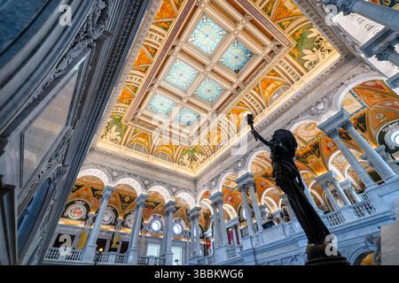 WASHINGTON DC – die große Halle des Thomas Jefferson Building an der Library of Congress verfügt über eine monumentale Marmortreppe, die von weiblichen Bronzestuppen mit hochgezogenen Armen flankiert wird, die brennerähnliche Elektroliere halten. Diese allegorischen Statuen, die in den 1890er Jahren vom Bildhauer Philip Martiny geschaffen wurden, dienen sowohl als dekorative Elemente als auch als funktionale Leuchten im kunstvollen Beaux-Arts-Innenraum. Die 1897 fertiggestellte große Halle zeigt kunstvolle Marmorsäulen, vergoldete Ornamente, Mosaikböden und eine Kassettendecke mit verkupferten Oberlichtern, die beispielhaft für die amerikanische Renaissance ist Stockfoto
