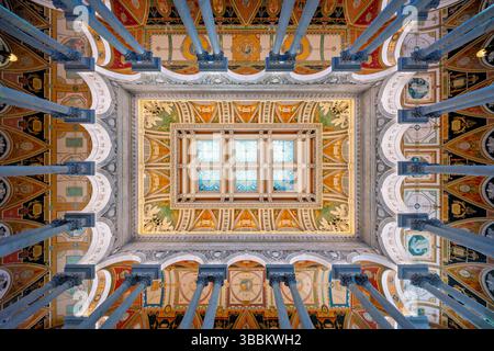 Haupthalle des Jefferson Building der Library of Congress in Washington DC / WASHINGTON DC – direkt nach oben in der Großen Halle des Thomas Jefferson Building an der Library of Congress zeigt eine kunstvoll verzierte Kassettendecke mit kunstvoll vergoldeten Rosetten und verkupferten Glasoberlichtern. Dieses Meisterwerk von Beaux-Arts wurde 1897 fertiggestellt und verfügt über 73 dekorative Rosetten in geometrischen Kassen, die natürliches Licht durch die Buntglasscheiben filtern lassen. Die Decke erhebt sich 75 Meter über dem Marmorboden und veranschaulicht mit ihrer Komplexität den Stil der amerikanischen Renaissance Stockfoto
