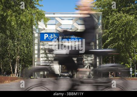 Amsterdam, Niederlande. Mai 2025. Ein Radfahrer fährt am Eingang zu einer Tiefgarage für Fahrräder in der Nähe einer U-Bahn-Station vorbei (Wischeffekt aufgrund langer Exposition). Quelle: David Breidert/dpa/Alamy Live News Stockfoto