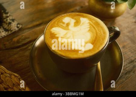 Eine Präsentation einer handgefertigten Tasse Schwan Latte Art in einem gemütlichen Café Stockfoto