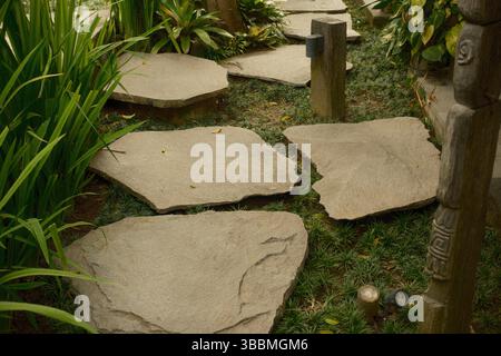 Ruhiger Gartenweg aus großen Natursteinstufen, umgeben von Grün Stockfoto