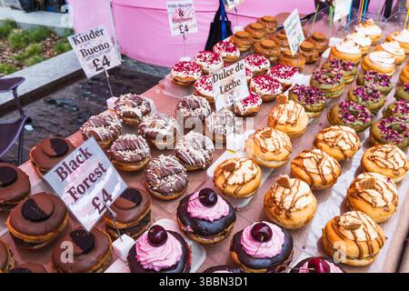 Auswahl an köstlichen Cupcakes mit Zuckerguss und Belägen im Außenbereich Stockfoto