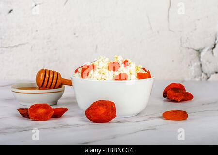 Getrocknete Aprikosen in frischem Hüttenkäse mit Honig. Gesunde Ernährung. Stockfoto