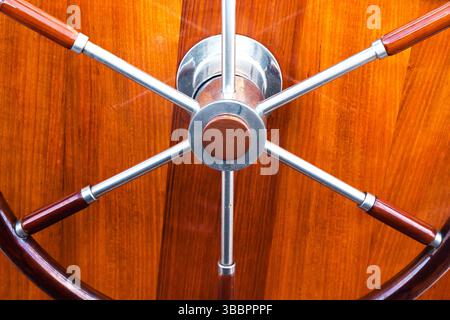 Klassisches, rundes Yachtlenkrad auf einem Holzrumpf, Nahaufnahme. Stockfoto
