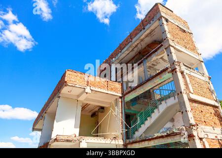 Baufälliges Gebäude, seine Struktur gegen den Himmel ausgesetzt. Abbruch mit Sichtbeton- und Stahlträgern. Die verfallende Struktur des Gebäudes Stockfoto