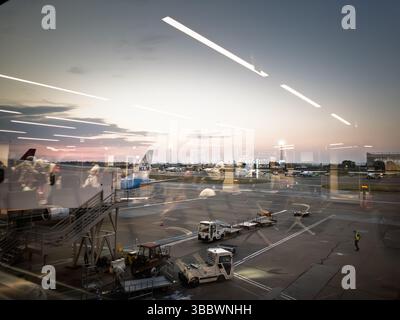 BELGRAD, SERBIEN - 21. AUGUST 2024: Morgenblick durch das Glas des Terminals auf Passagiere, die in einen KLM Dutch Jet über eine Jetbrücke unter dem Vorfeldfahrzeug einsteigen Stockfoto