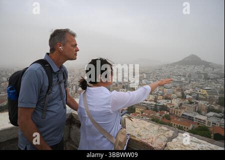 Athen, Griechenland, 16. Mai 2025. Besucher blicken über die Stadt, während Athen von Staubwolken bedeckt ist. Eine dicke Decke aus Sahara-Staub fegte am Freitag über die griechische Hauptstadt und ließ die Stadt trüben und warnte die Behörden. Quelle: Dimitris Aspiotis/Alamy Live News Stockfoto