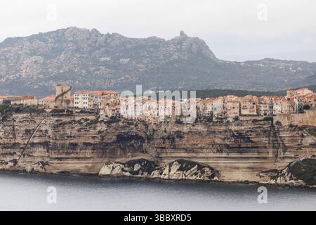 20. April 2025, Frankreich, Bonifacio: Blick auf die Stadt Bonifacio auf der Insel Korsika (Frankreich) am 20.04.2025. Sie können die mittelalterliche Altstadt (Ville Haute) auf einem Felsvorsprung aus Kalk- und Sandstein sehen, der in großen Teilen senkrecht zum Meer abfällt, und die sogenannte Treppe des Königs von Aragon. Bonifacio (Bonifaziu) ist eine Hafenstadt im Süden der französischen Mittelmeerinsel Korsika (Corse, Korsika) im Departement Corse-du-Sud. Die Altstadt liegt auf einem halbinnenähnlichen Felsplateau und ist eine der schönsten der Insel Stockfoto
