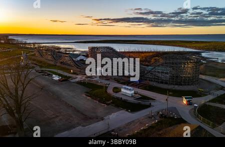 Blick aus der Vogelperspektive über den Bay Beach Amusement Park in Green Bay Wisconsin bei Sonnenuntergang mit Achterbahn, Riesenrad und strahlendem Himmel. Stockfoto